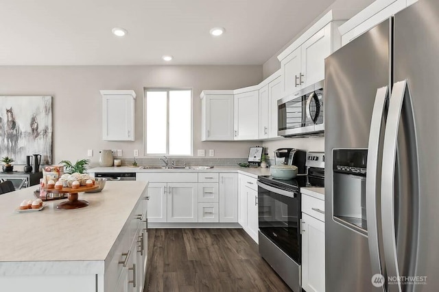 kitchen with a sink, white cabinets, light countertops, appliances with stainless steel finishes, and recessed lighting