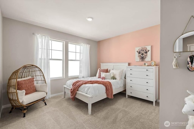 bedroom with light colored carpet and baseboards