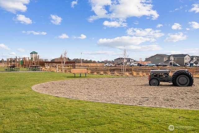 exterior space with playground community, a yard, and fence