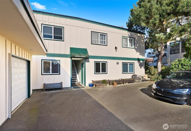 514 Bell St, Edmonds, WA 98020 - view of front facade featuring board and batten siding, stairway, and a garage