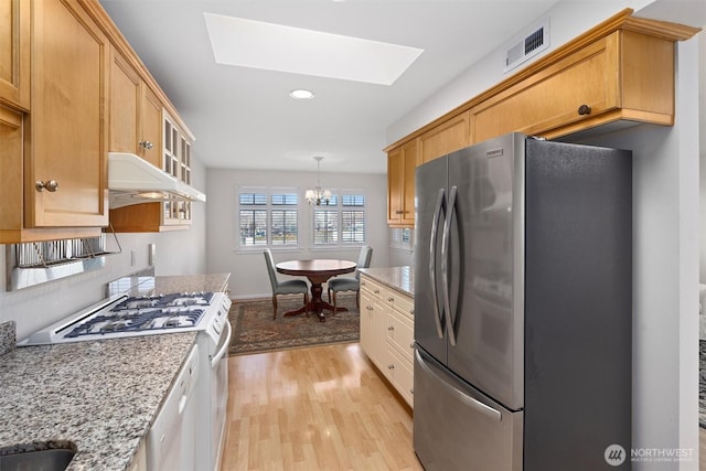 514 Bell St, Edmonds, WA 98020 - kitchen featuring a skylight, visible vents, white appliances, under cabinet range hood, and light wood-style floors