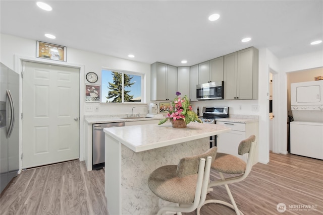 11 Ridge Loop Rd, Cle Elum, WA 98922 - kitchen featuring appliances with stainless steel finishes, stacked washing machine and dryer, light wood-type flooring, a kitchen island, and recessed lighting