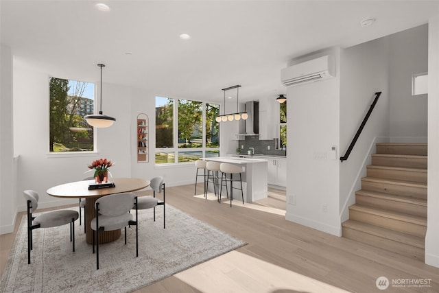 1625B 21st Ave, Seattle, WA 98122 - dining space featuring a wall unit AC, light wood-style floors, baseboards, stairs, and recessed lighting