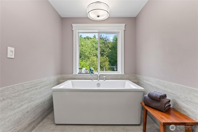 856 Hilltop Ave, Kent, WA 98031 - bathroom with tile walls, a wainscoted wall, and a freestanding bath