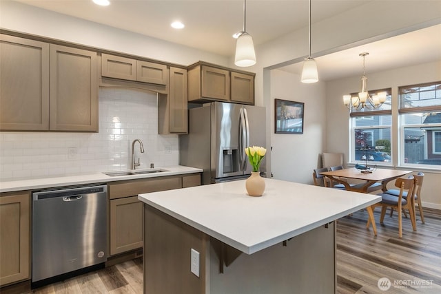 3215 64th Ln SW, Olympia, WA 98512 - kitchen featuring a sink, wood finished floors, decorative backsplash, light countertops, and appliances with stainless steel finishes