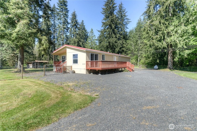 manufactured / mobile home featuring a deck and a front yard