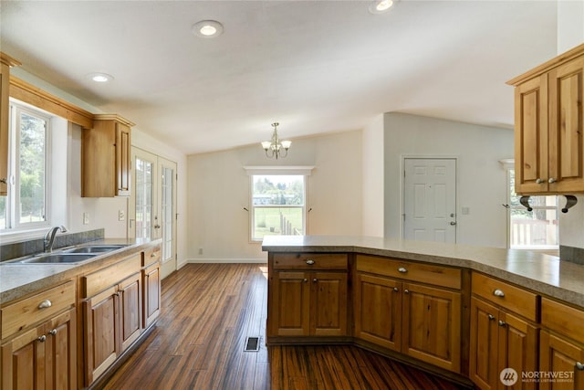 kitchen with a sink, a chandelier, dark wood-type flooring, recessed lighting, and baseboards