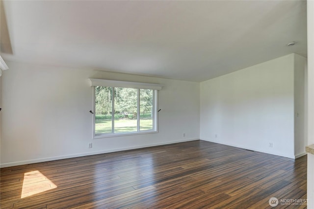 unfurnished room featuring dark wood-style flooring and baseboards