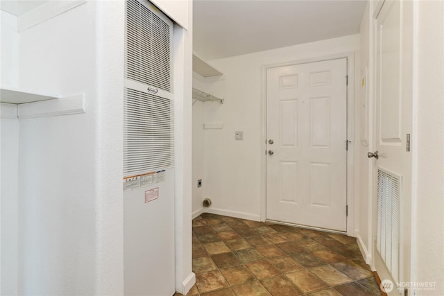 clothes washing area with a heating unit, stone finish floors, hookup for an electric dryer, and baseboards