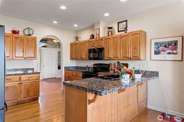 1552 Huntwood Ln, East Wenatchee, WA 98802 - kitchen with black appliances, a sink, light wood finished floors, a kitchen bar, and a peninsula