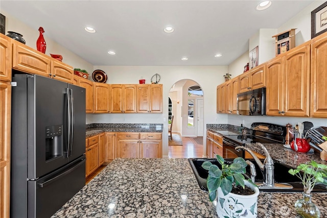 1552 Huntwood Ln, East Wenatchee, WA 98802 - kitchen featuring black appliances, arched walkways, recessed lighting, dark stone countertops, and a sink