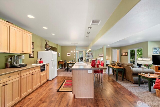 1552 Huntwood Ln, East Wenatchee, WA 98802 - kitchen with light brown cabinets, open floor plan, wood finished floors, a kitchen bar, and recessed lighting