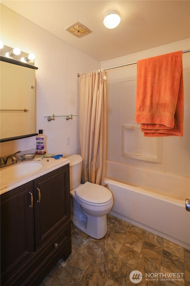 bathroom featuring toilet, vanity, and shower / tub combo