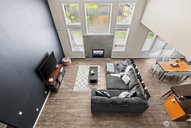 4002 33rd St NE, Tacoma, WA 98422 - living area featuring wood finished floors, a tiled fireplace, baseboards, and a high ceiling