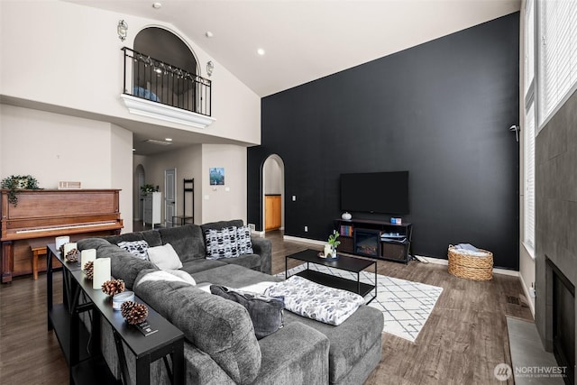 4002 33rd St NE, Tacoma, WA 98422 - living area featuring arched walkways, high vaulted ceiling, wood finished floors, a fireplace with flush hearth, and baseboards