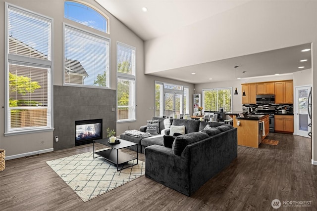 4002 33rd St NE, Tacoma, WA 98422 - living room with dark wood-style floors, a high ceiling, a tiled fireplace, baseboards, and recessed lighting
