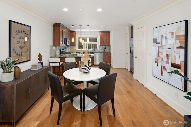 dining room with ornamental molding, light wood-type flooring, recessed lighting, and baseboards