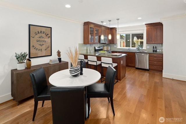 dining space featuring recessed lighting, light wood-type flooring, crown molding, and baseboards