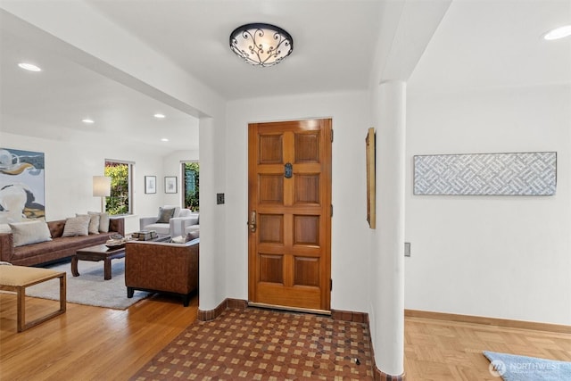 foyer entrance with baseboards and recessed lighting