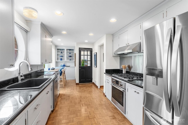 kitchen featuring stainless steel appliances, under cabinet range hood, a sink, dark countertops, and recessed lighting