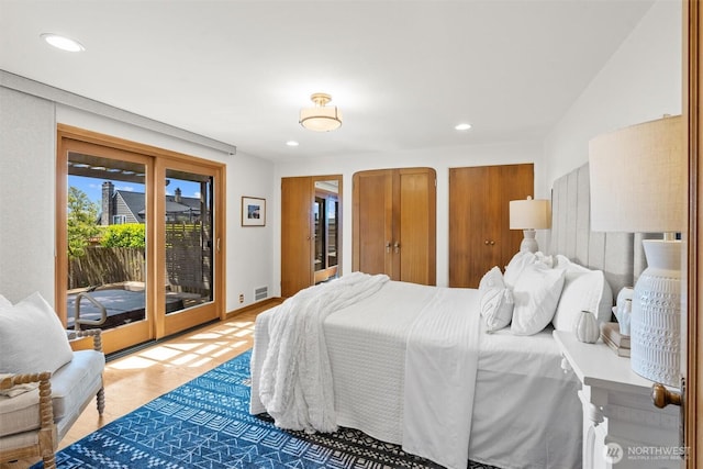 bedroom featuring access to outside, recessed lighting, wood finished floors, and multiple closets