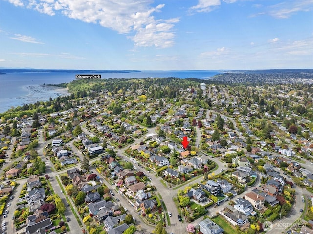aerial view of property's location featuring a nearby body of water and nearby suburban area