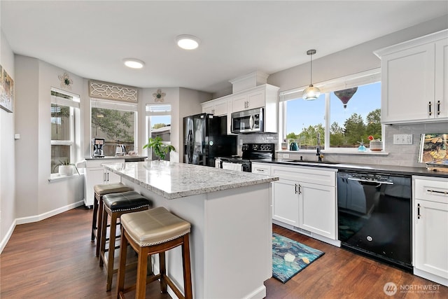 17915 69th Avenue Ct E, Puyallup, WA 98375 - kitchen featuring black appliances, a sink, tasteful backsplash, a breakfast bar area, and a center island