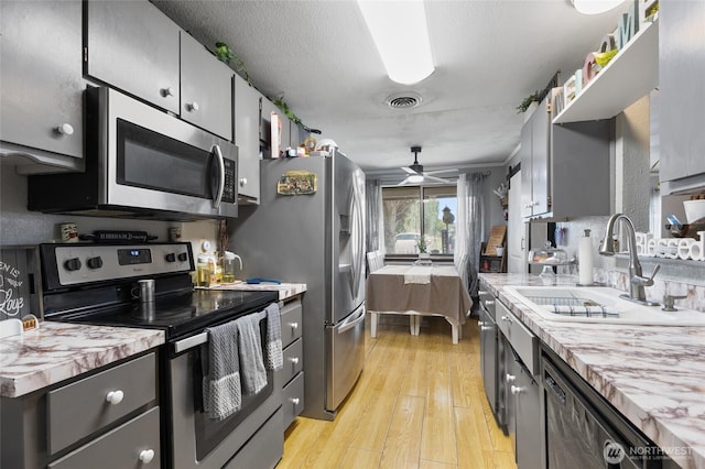 322 W 8th St, Warden, WA 98857 - kitchen with stainless steel appliances, a sink, ceiling fan, light wood finished floors, and light countertops