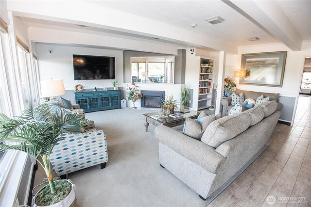 643 Oceans Shores Blvd NW Unit 102, Ocean Shores, WA 98569 - living room with beam ceiling, a glass covered fireplace, and wood finished floors