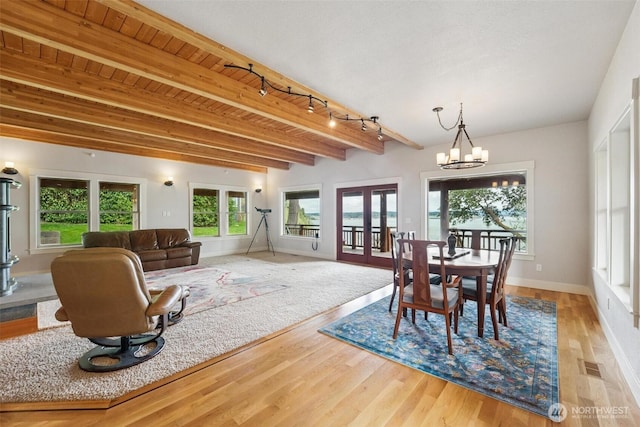 1005 Cavalero Rd, Camano Island, WA 98282 - dining area with french doors, wood finished floors, visible vents, beamed ceiling, and a notable chandelier