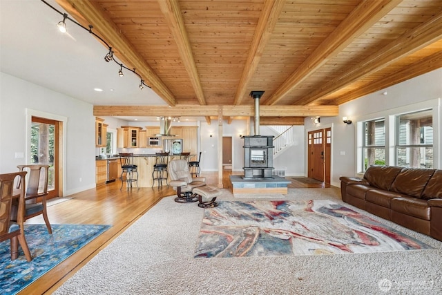 1005 Cavalero Rd, Camano Island, WA 98282 - living area with a wood stove, rail lighting, visible vents, light wood-style flooring, and beamed ceiling