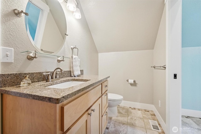 1005 Cavalero Rd, Camano Island, WA 98282 - bathroom with toilet, visible vents, baseboards, vaulted ceiling, and vanity