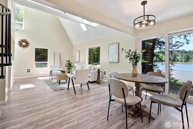 15802 67th Ave NW, Gig Harbor, WA 98332 - dining room with baseboards, light wood-style floors, a skylight, and high vaulted ceiling