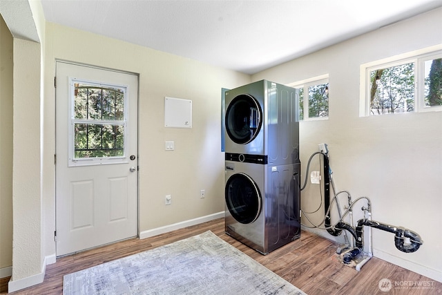 15802 67th Ave NW, Gig Harbor, WA 98332 - laundry room featuring stacked washer / drying machine, wood finished floors, and baseboards