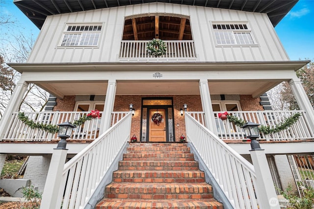 640 N Elm St, Colville, WA 99114 - view of front of property featuring a porch, brick siding, a balcony, stairway, and board and batten siding