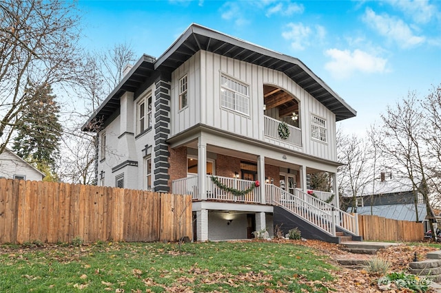 640 N Elm St, Colville, WA 99114 - view of front facade featuring covered porch, fence, board and batten siding, stairway, and brick siding