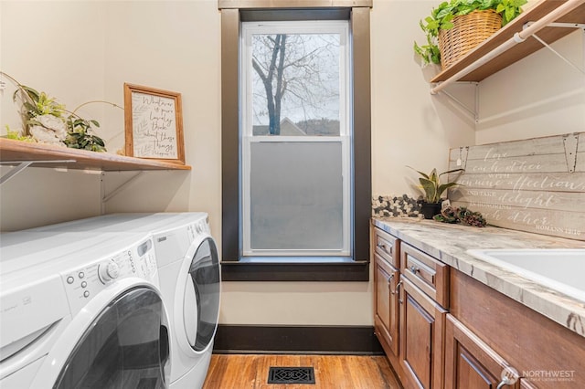 640 N Elm St, Colville, WA 99114 - clothes washing area with light wood finished floors, cabinet space, independent washer and dryer, and visible vents