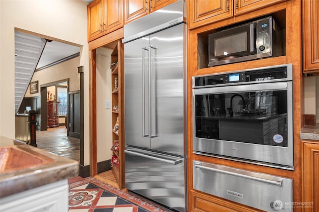 640 N Elm St, Colville, WA 99114 - kitchen with brown cabinetry, stainless steel appliances, baseboards, and a warming drawer