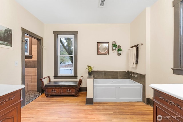 640 N Elm St, Colville, WA 99114 - bathroom featuring vanity, visible vents, a bath, and wood finished floors
