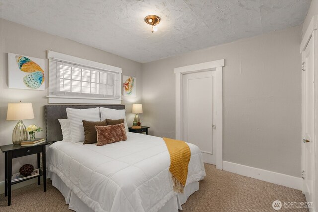 carpeted bedroom with baseboards and a textured ceiling
