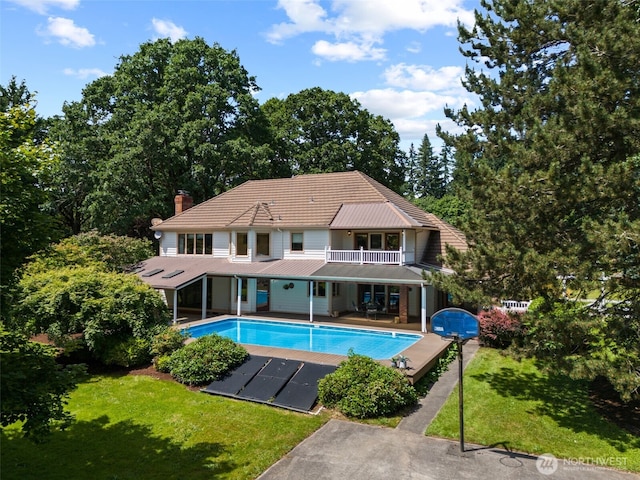 7117 NE 176th Ave, Vancouver, WA 98682 - back of property featuring a balcony, an outdoor pool, a lawn, and a chimney