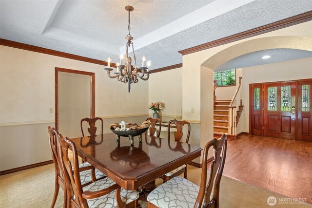 7117 NE 176th Ave, Vancouver, WA 98682 - dining space featuring arched walkways, stairway, a tray ceiling, a textured ceiling, and wood finished floors
