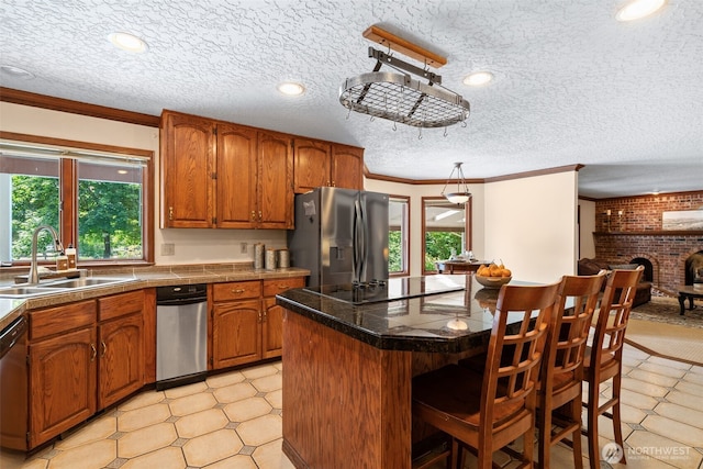 7117 NE 176th Ave, Vancouver, WA 98682 - kitchen featuring stainless steel appliances, plenty of natural light, brown cabinets, crown molding, and a breakfast bar area