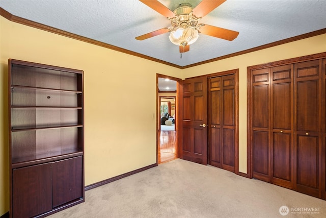 7117 NE 176th Ave, Vancouver, WA 98682 - unfurnished bedroom with light carpet, multiple closets, a textured ceiling, crown molding, and ceiling fan