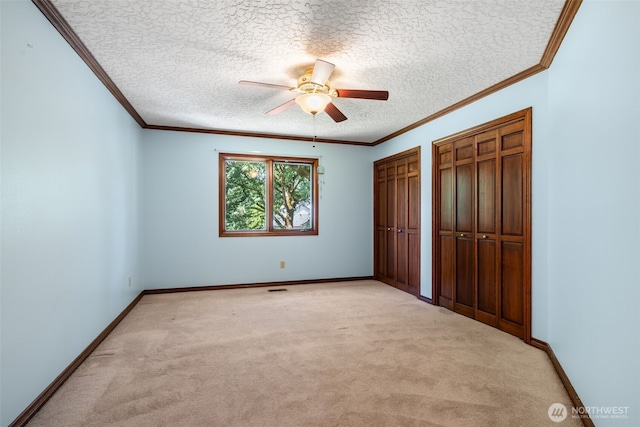 7117 NE 176th Ave, Vancouver, WA 98682 - unfurnished bedroom with multiple closets, a textured ceiling, light colored carpet, ornamental molding, and a ceiling fan