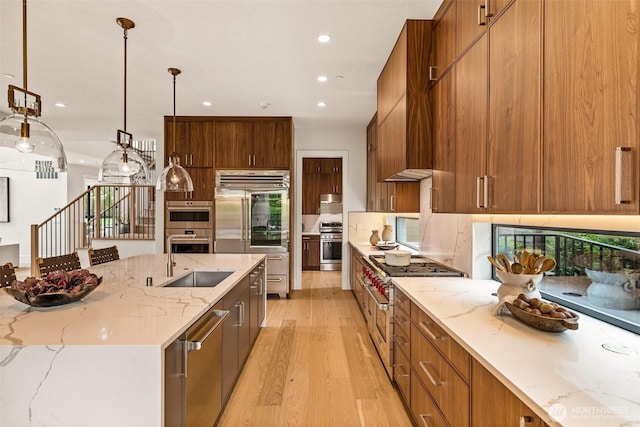 8458 NE 9th St, Medina, WA 98039 - kitchen with premium appliances, modern cabinets, a sink, light wood-type flooring, and recessed lighting