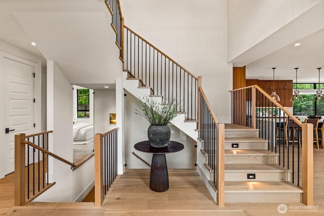 8458 NE 9th St, Medina, WA 98039 - staircase with wood finished floors, a high ceiling, and recessed lighting