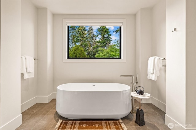 8458 NE 9th St, Medina, WA 98039 - bathroom featuring a freestanding bath, baseboards, and tile patterned floors