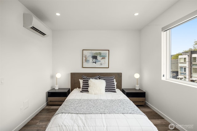 bedroom featuring an AC wall unit, recessed lighting, dark wood-type flooring, and baseboards