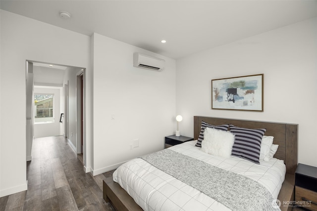 bedroom featuring a wall mounted AC, wood finished floors, recessed lighting, and baseboards